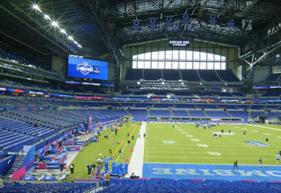 A stadium with people playing football.