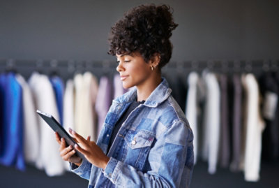 A woman in an apparel store checking her tablet