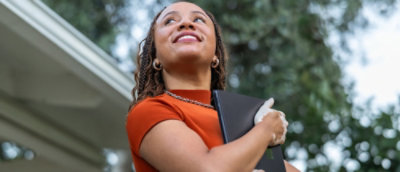 A woman holding a laptop.