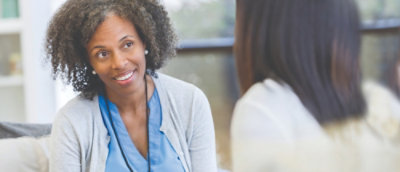 A woman smiling while holding a tablet.