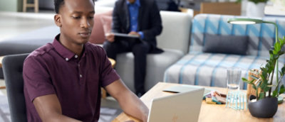 A man sitting at a table with a laptop.