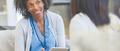 Usmívající se žena, která drží tablet.