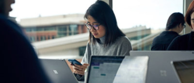 Žena, která se dívá na mobilní telefon.