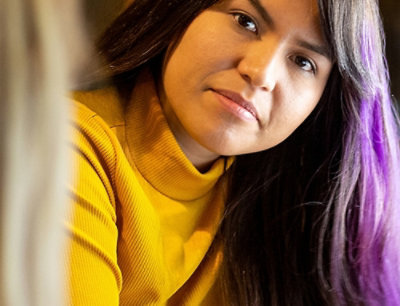 Detailní záběr na osobu ve žlutém roláku.