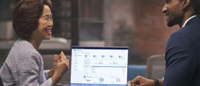 Zwei Personen, die miteinander sprechen, während sie auf den Bildschirm schauen.