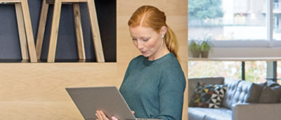A couch with pillows in front of a window.