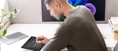 A person sitting at a desk using a laptop.