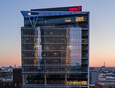 A building with the text CDW on it, reflecting the surrounding cityscape.