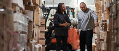 A man and a woman standing in a warehouse.