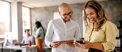 A man and woman looking at a tablet.