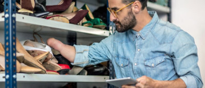 A man with glasses and a beard holding a tablet.