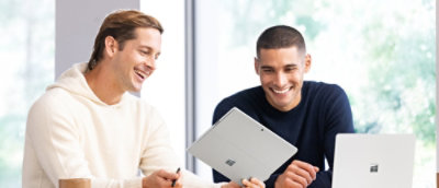 Two people looking at a tablet together.