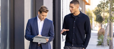 A man in a suit using a tablet.