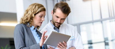 A man and woman looking at a tablet.