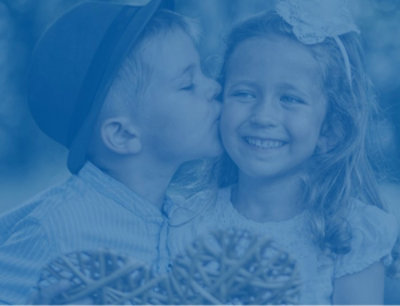 A boy wearing a hat and a girl smiling.