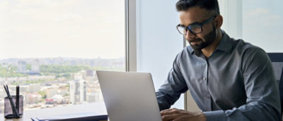 A man sitting at a desk with a laptop.