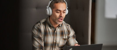 A person wearing headphones and using a laptop.