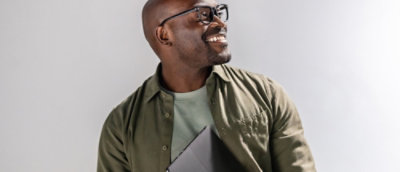 A man wearing glasses and a white shirt smiling.