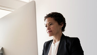 A person sitting at a white computer desk.