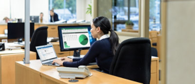 A woman sitting at a desk working on a computer.