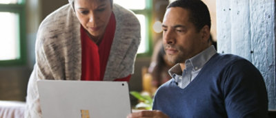A woman and a man looking at a laptop.