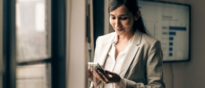 A woman in a white suit standing indoors.