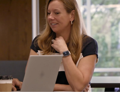 A woman sitting at a table with a laptop