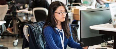 A person sitting on a chair using a laptop.