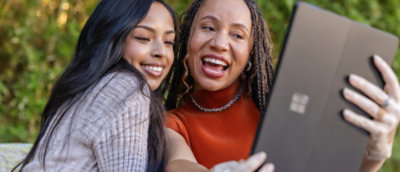 Two women are looking at a tablet.