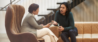 A man and woman sitting on chairs talking.