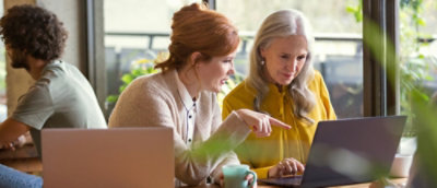 A woman pointing at a laptop screen.