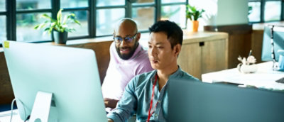A group of men looking at a computer screen.