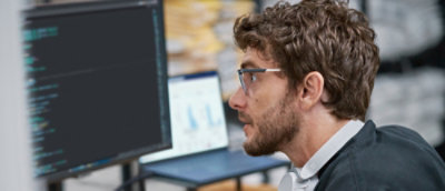 A person wearing glasses is looking at a computer screen.