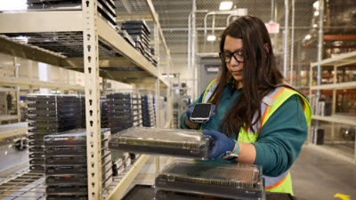 A person holding a phone and a package.
