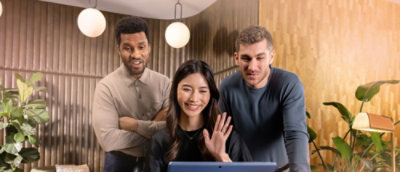 A group of people standing around a woman waving her hand.