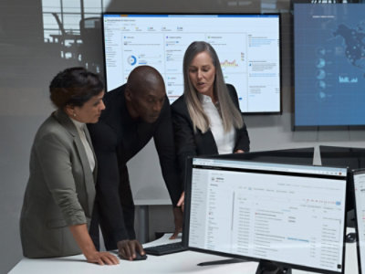 Three persons in an office looking at desktop