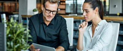A woman and a man looking at a tablet