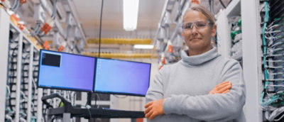 Человек со скрещенными руками перед компьютерными мониторами