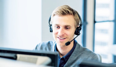 Person with headset at computer monitors.