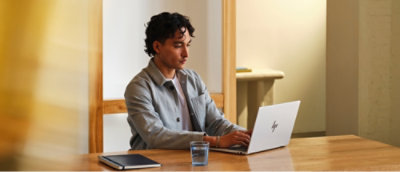A person typing on a laptop at a table.