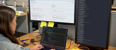 A person working on a laptop at a desk.