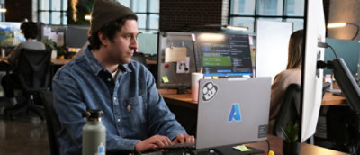 A person sitting at a desk using a laptop.