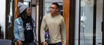 A person in a sweater holding a folder with visible text that reads Ards.