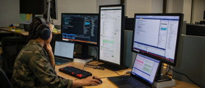 A desk with multiple computer monitors and a laptop.