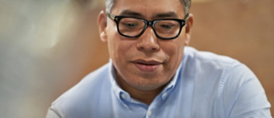 A man wearing glasses and a blue shirt.
