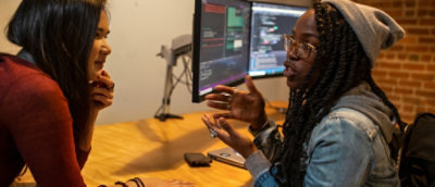 A person sitting at a desk with a computer screen.