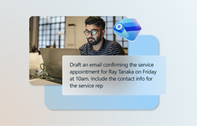 A man with glasses and a beard sitting at a desk with a laptop.