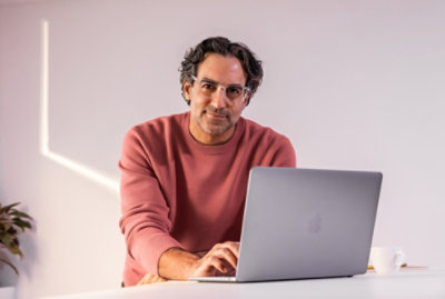 A man in glasses using a laptop.