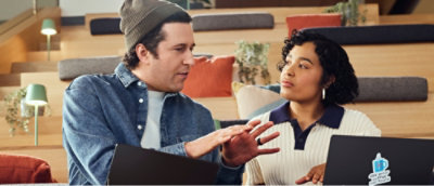 Two people talking to each other while looking at the screen.