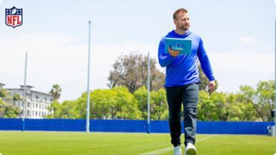 A person walking on ground with a tab in hand.